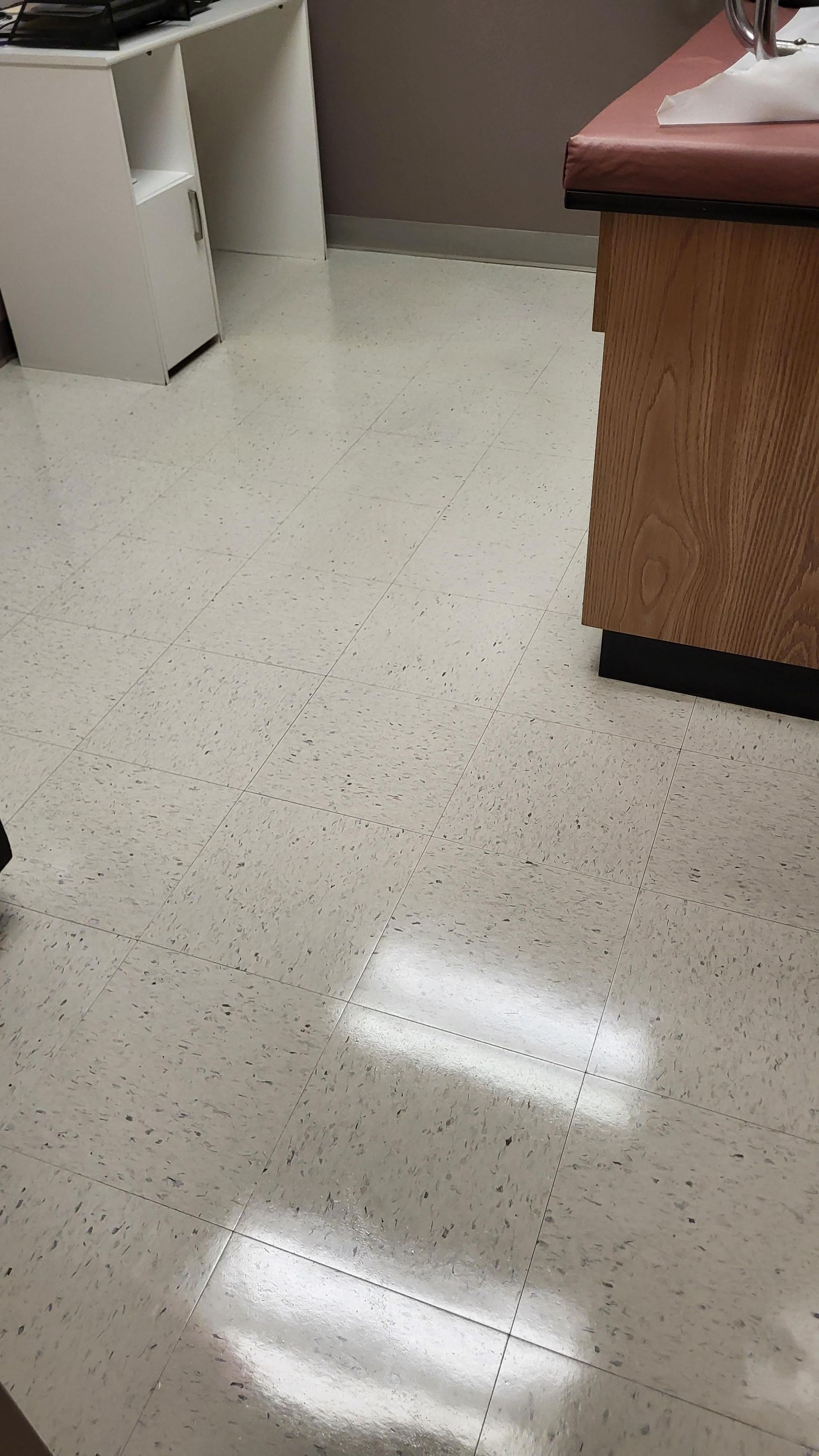A close up of a shiny white floor in a room.