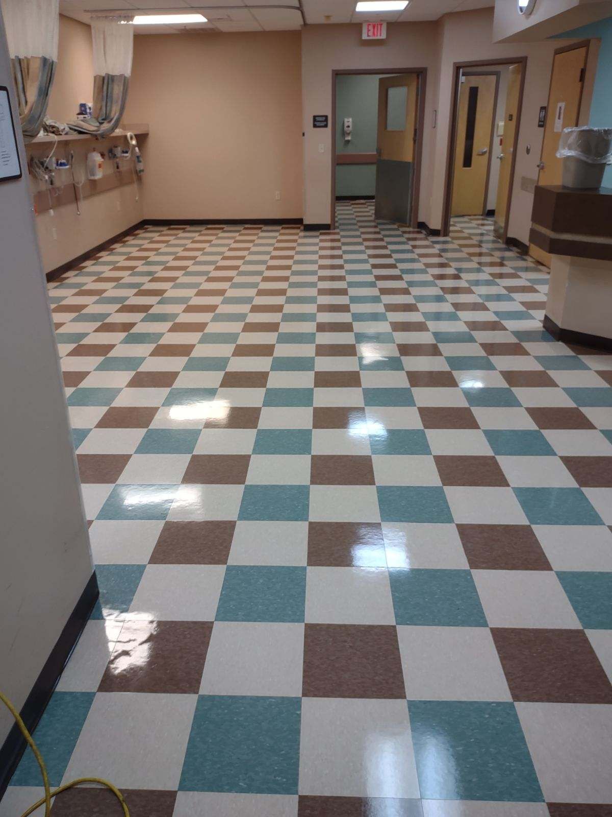 A hallway with a checkered floor and an exit sign