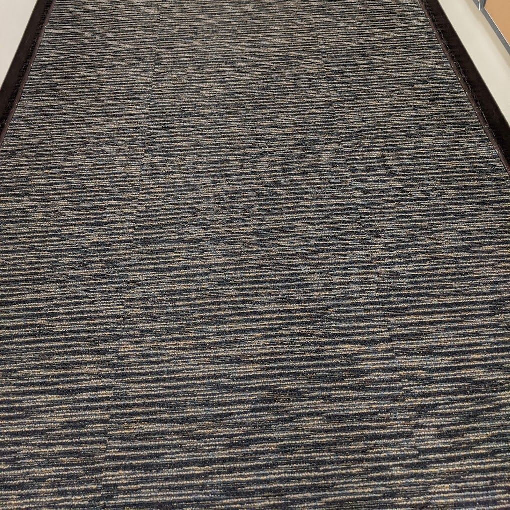 A black and white rug with a black border is on the floor.