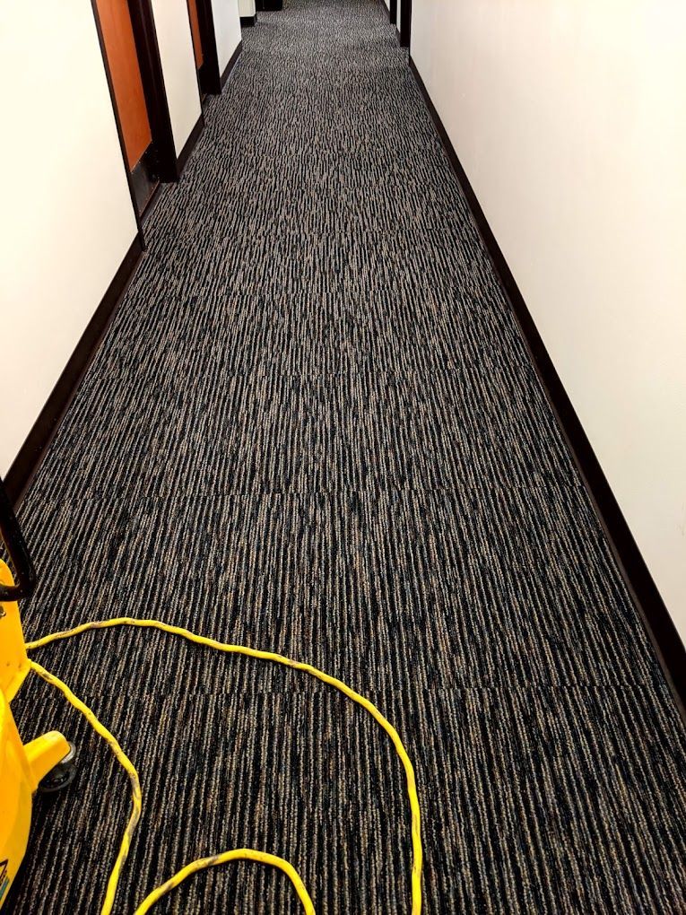 A long hallway with a yellow vacuum cleaner on the floor.