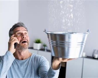 Blue water pipes, with brass fittings, run along a concrete block wall.