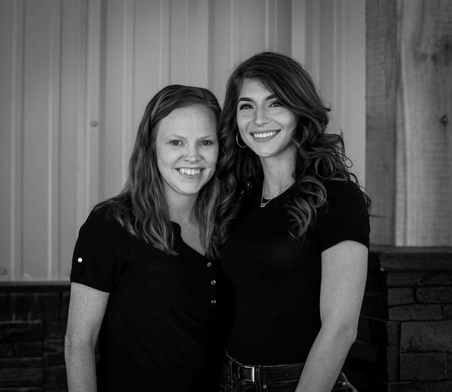 Two women are posing for a picture together in a black and white photo.