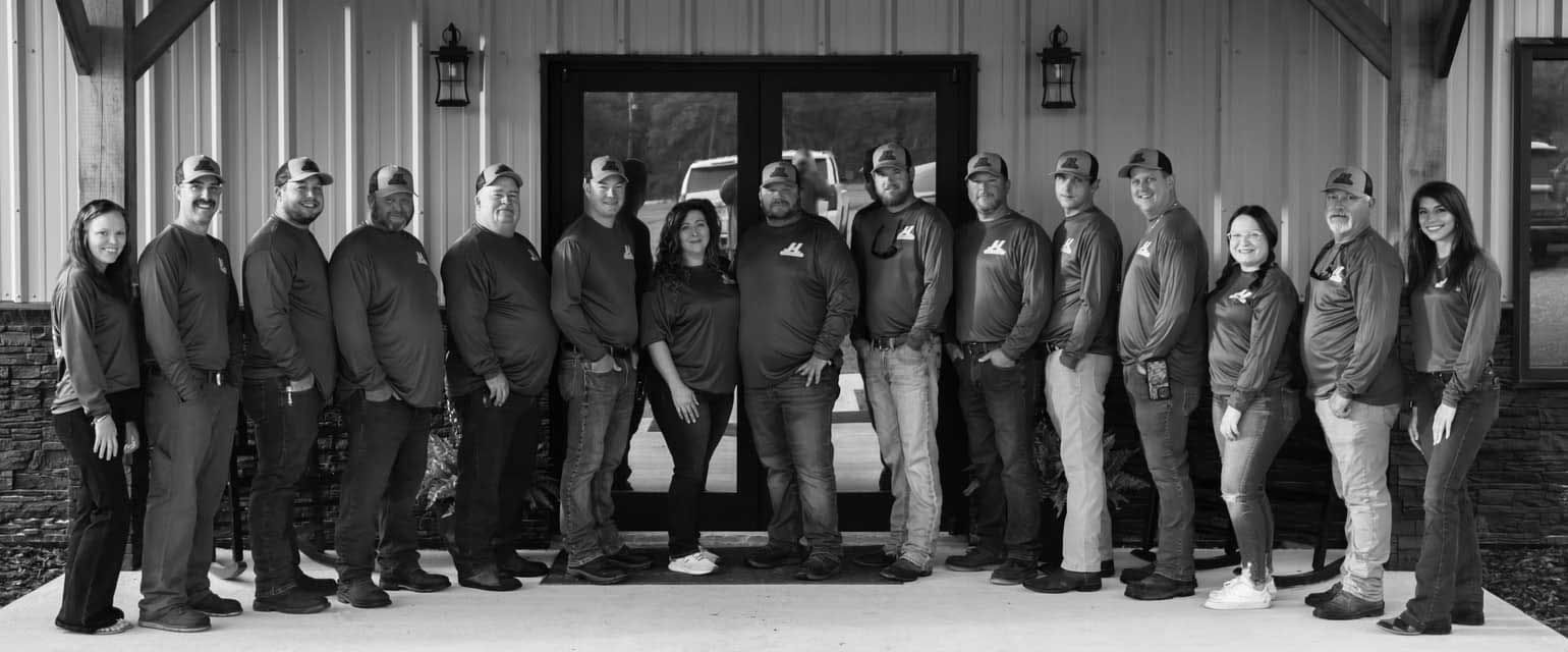 A black and white photo of a group of people standing in front of a building.