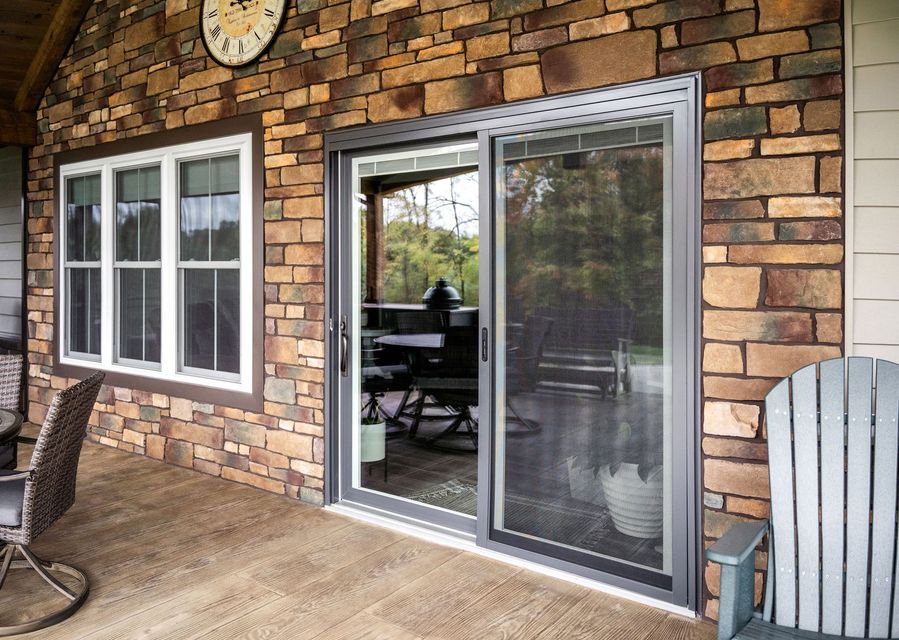A brick house with a sliding glass door and a clock on the wall.