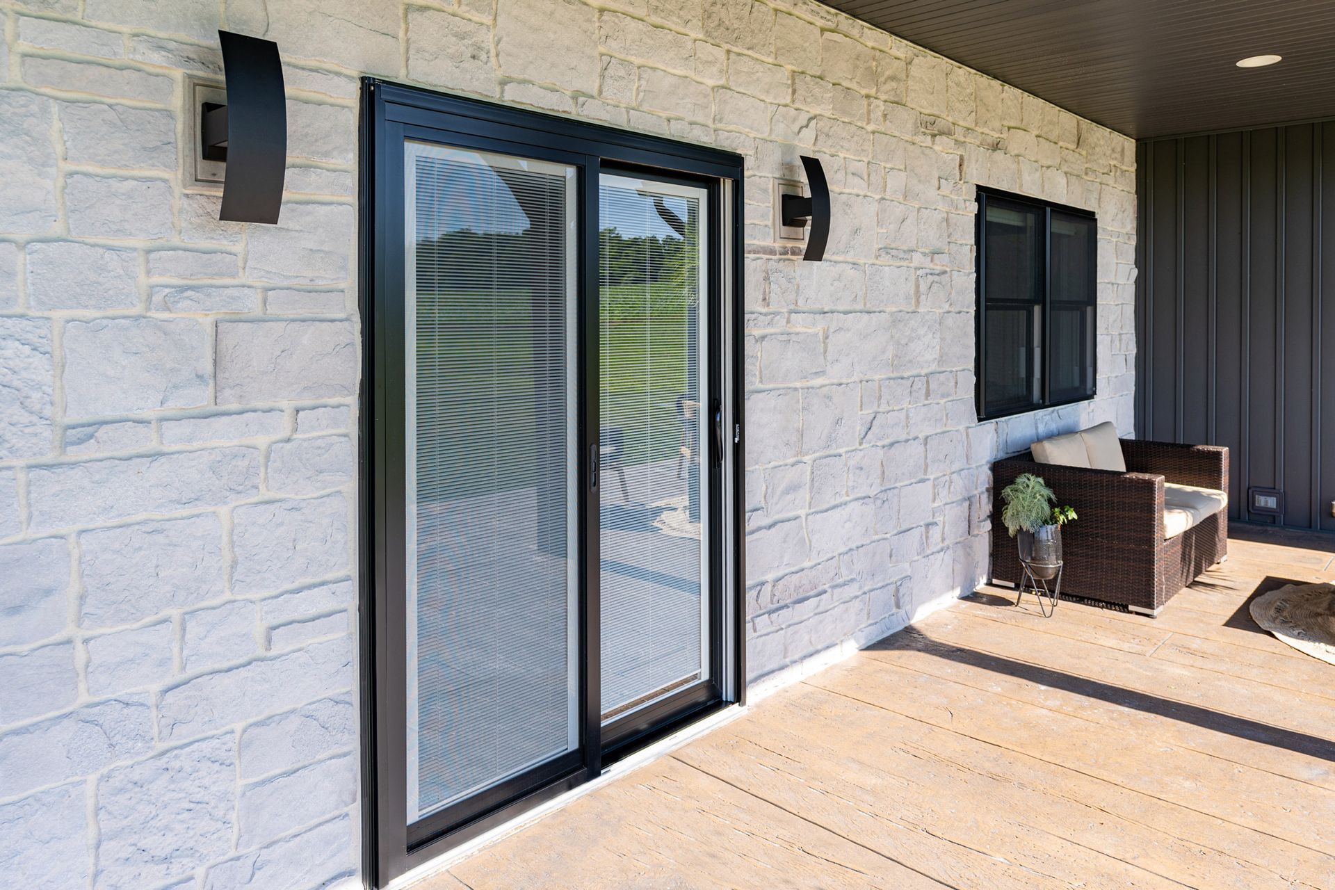 A brick house with a sliding glass door and a clock on the wall.