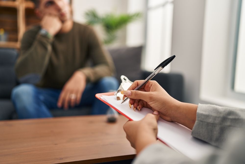 A Woman Is Sitting On A Couch Talking To Another Woman — Noosa Psychological Services in Noosa Heads, QLD
