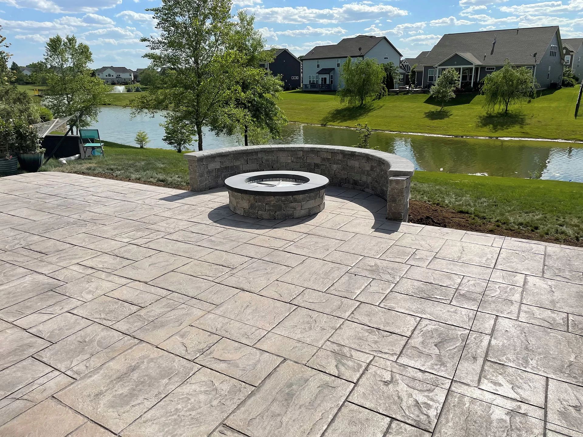 large concrete patio with fire pit and wall on a home in Signature of Solon