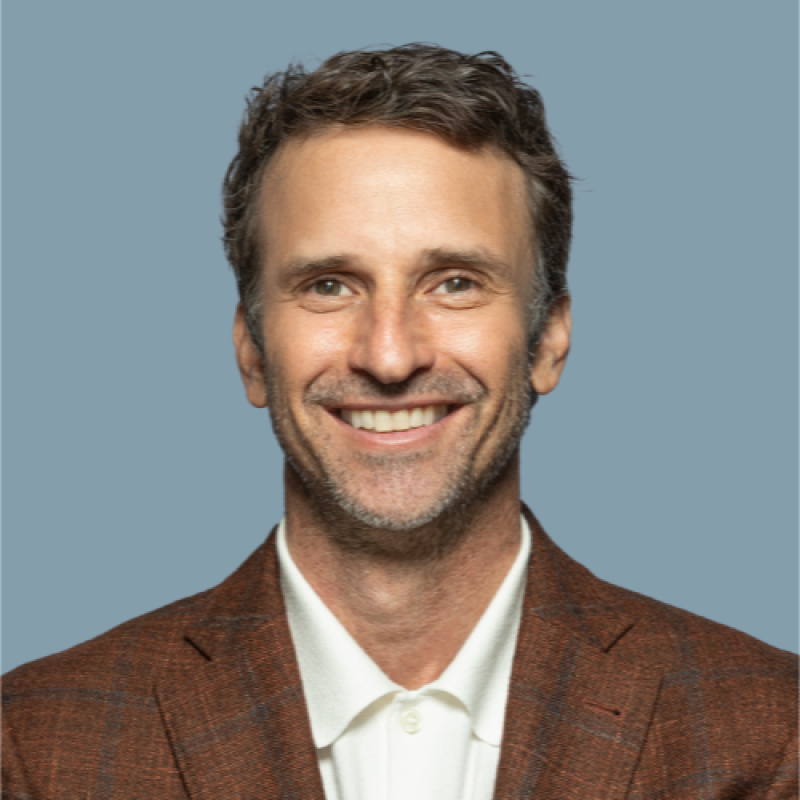 A woman in a pink dress is blowing a kiss while holding a microphone.