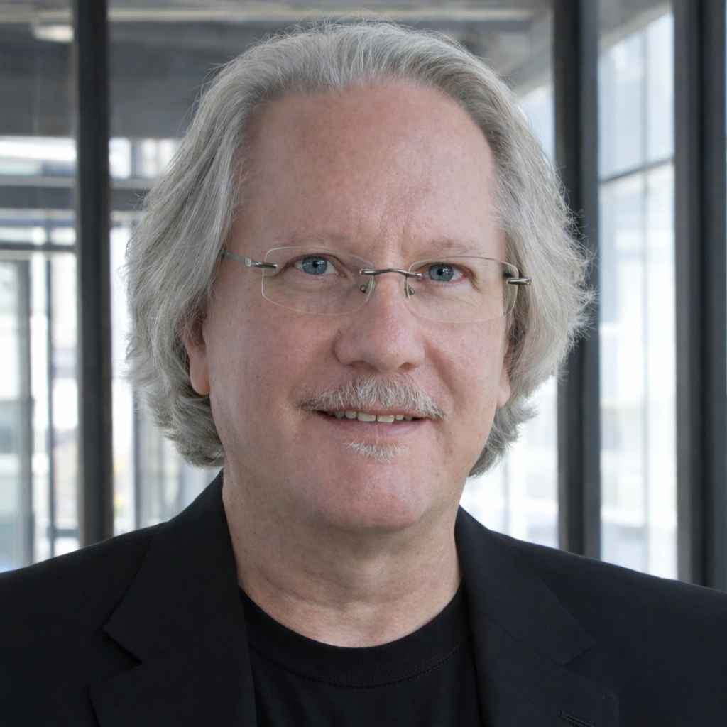 A man wearing a black shirt that says `` be great '' is giving a thumbs up.