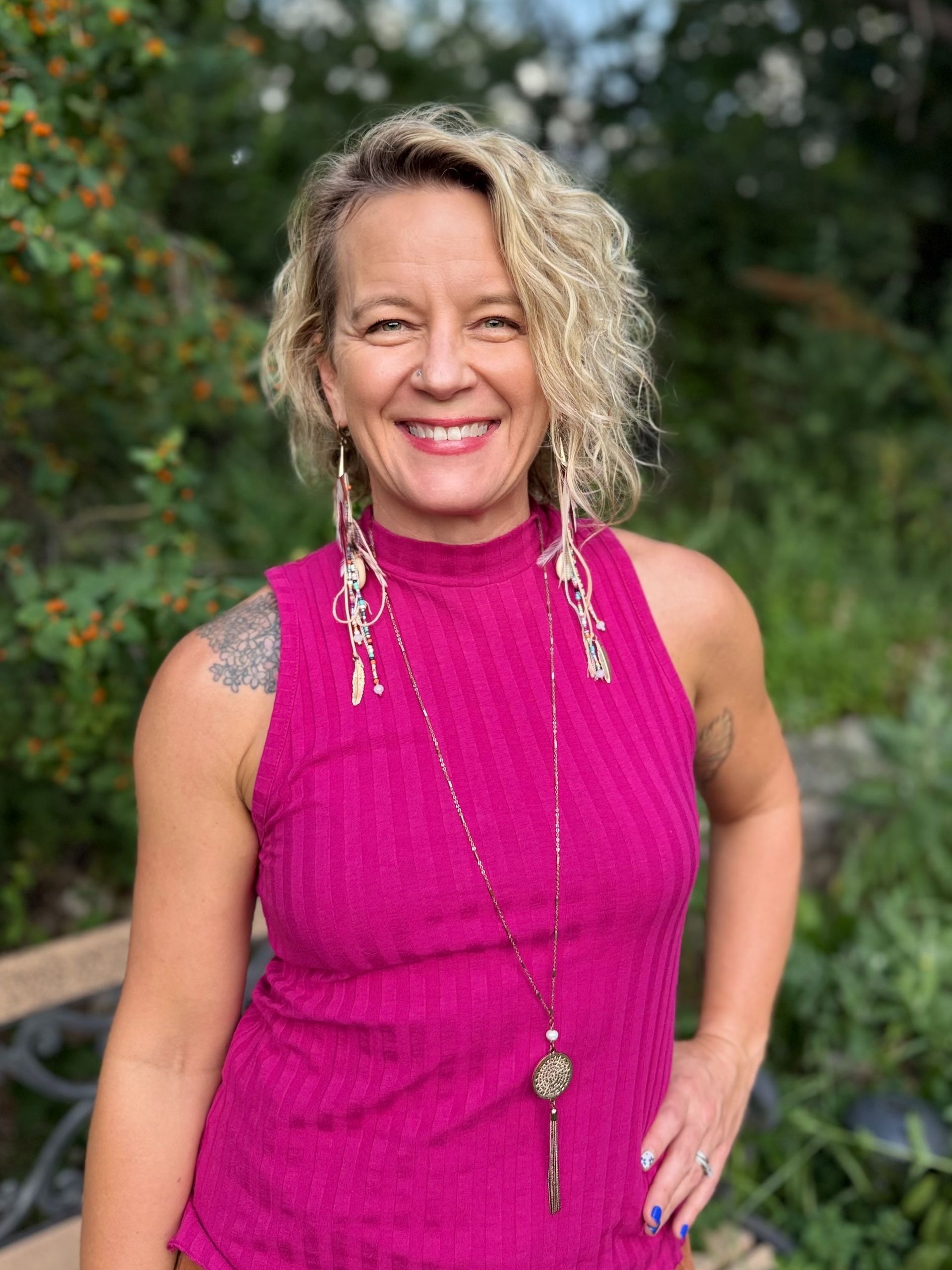 A woman with a tattoo on her arm is smiling for the camera