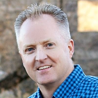 A man with dreadlocks and a beard is smiling for the camera.