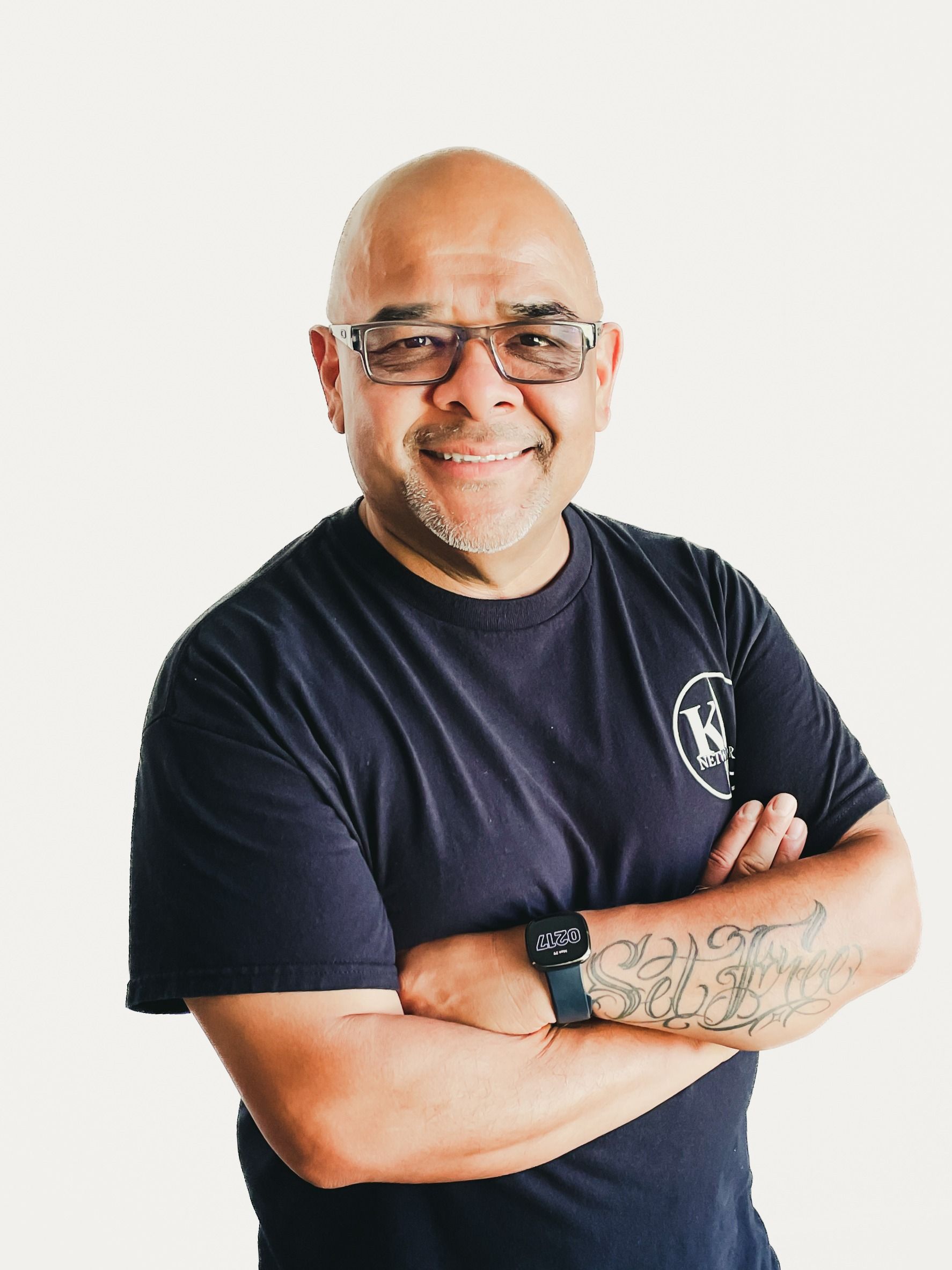 A man wearing a black shirt that says `` be great '' is giving a thumbs up.