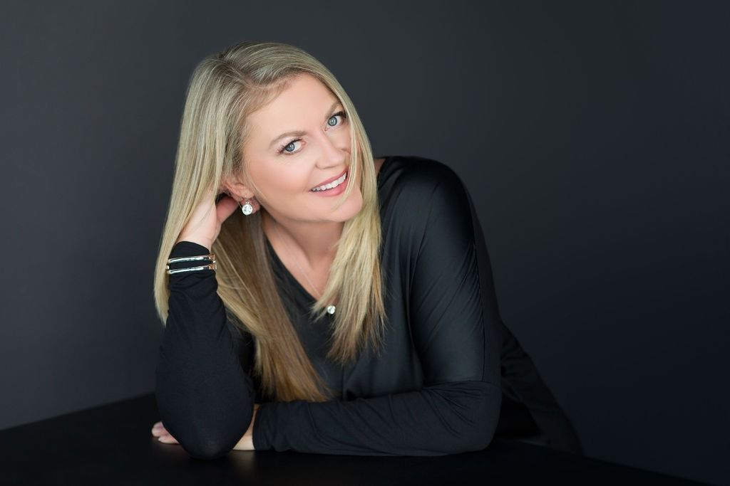 A man wearing a black shirt that says `` be great '' is giving a thumbs up.