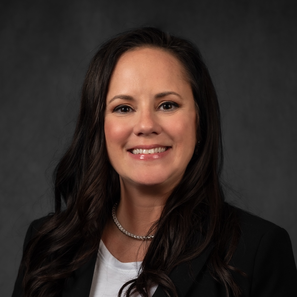 A man wearing a black shirt that says `` be great '' is giving a thumbs up.