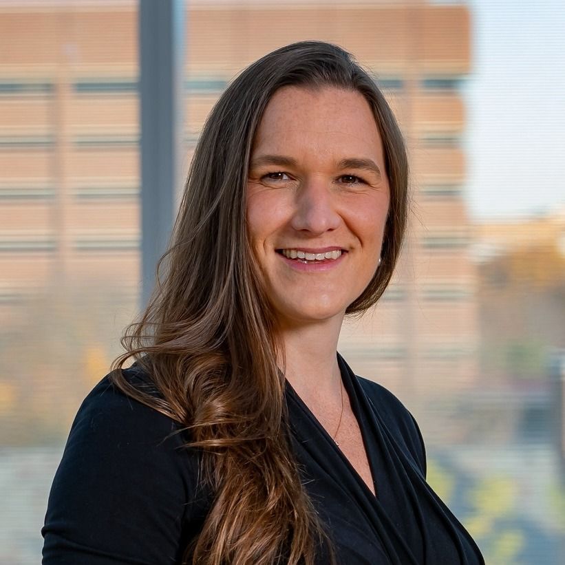 A woman with a tattoo on her arm is smiling for the camera