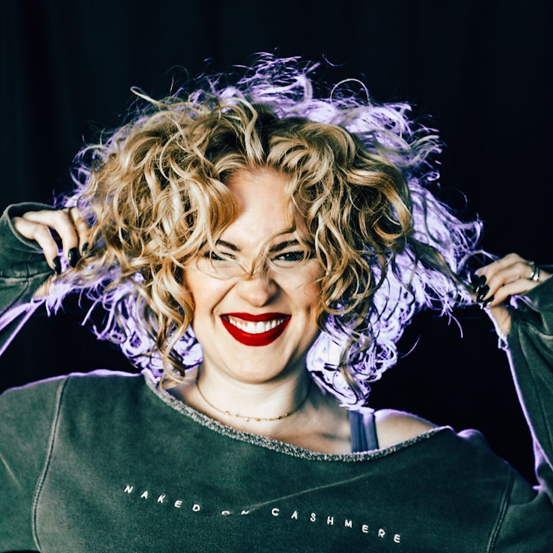 A man with dreadlocks and a beard is smiling for the camera.