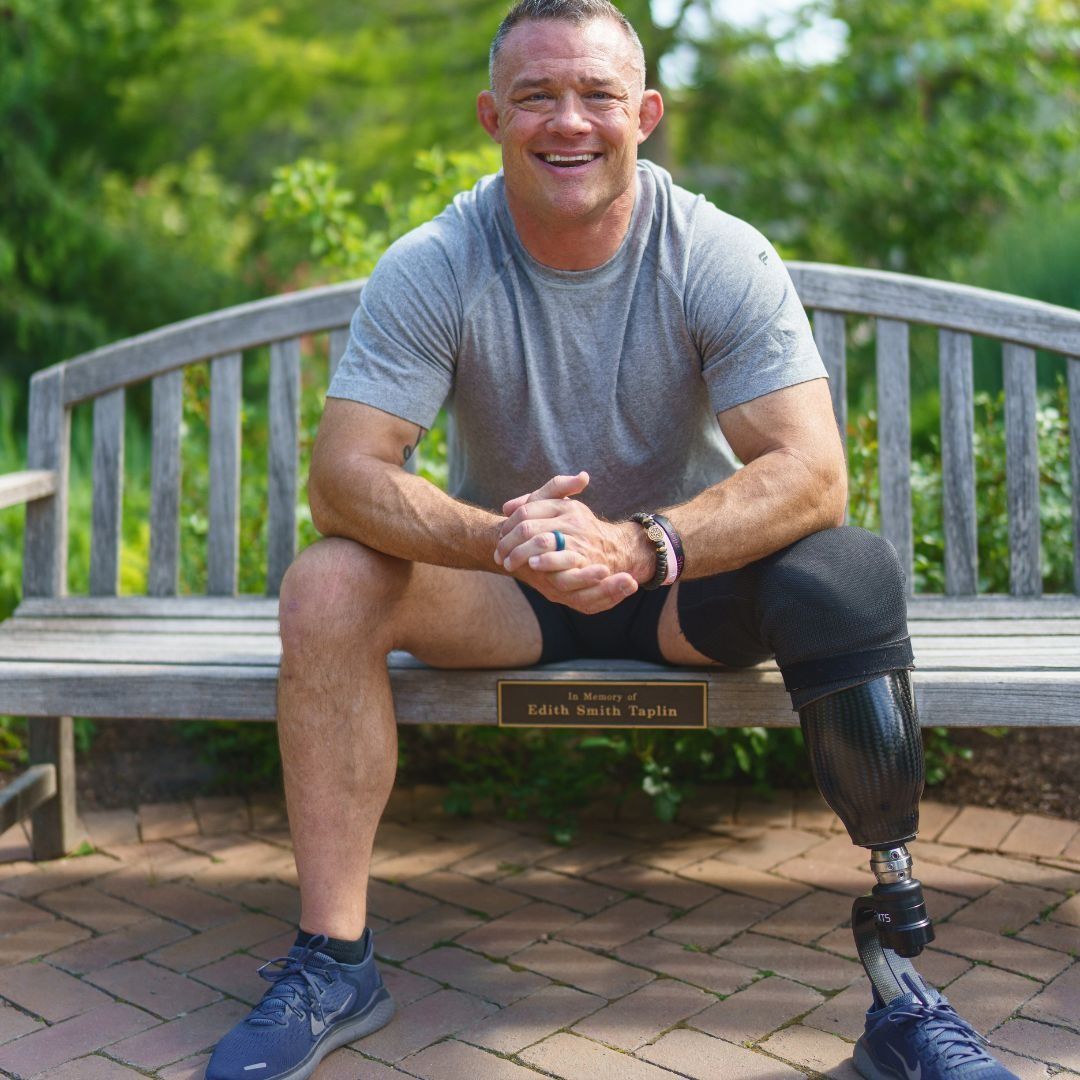 A woman with a tattoo on her arm is smiling for the camera