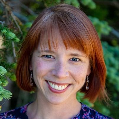 A man wearing a black shirt that says `` be great '' is giving a thumbs up.