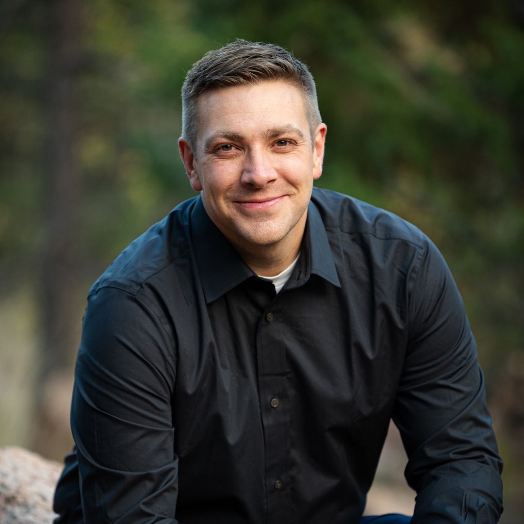A man with dreadlocks and a beard is smiling for the camera.
