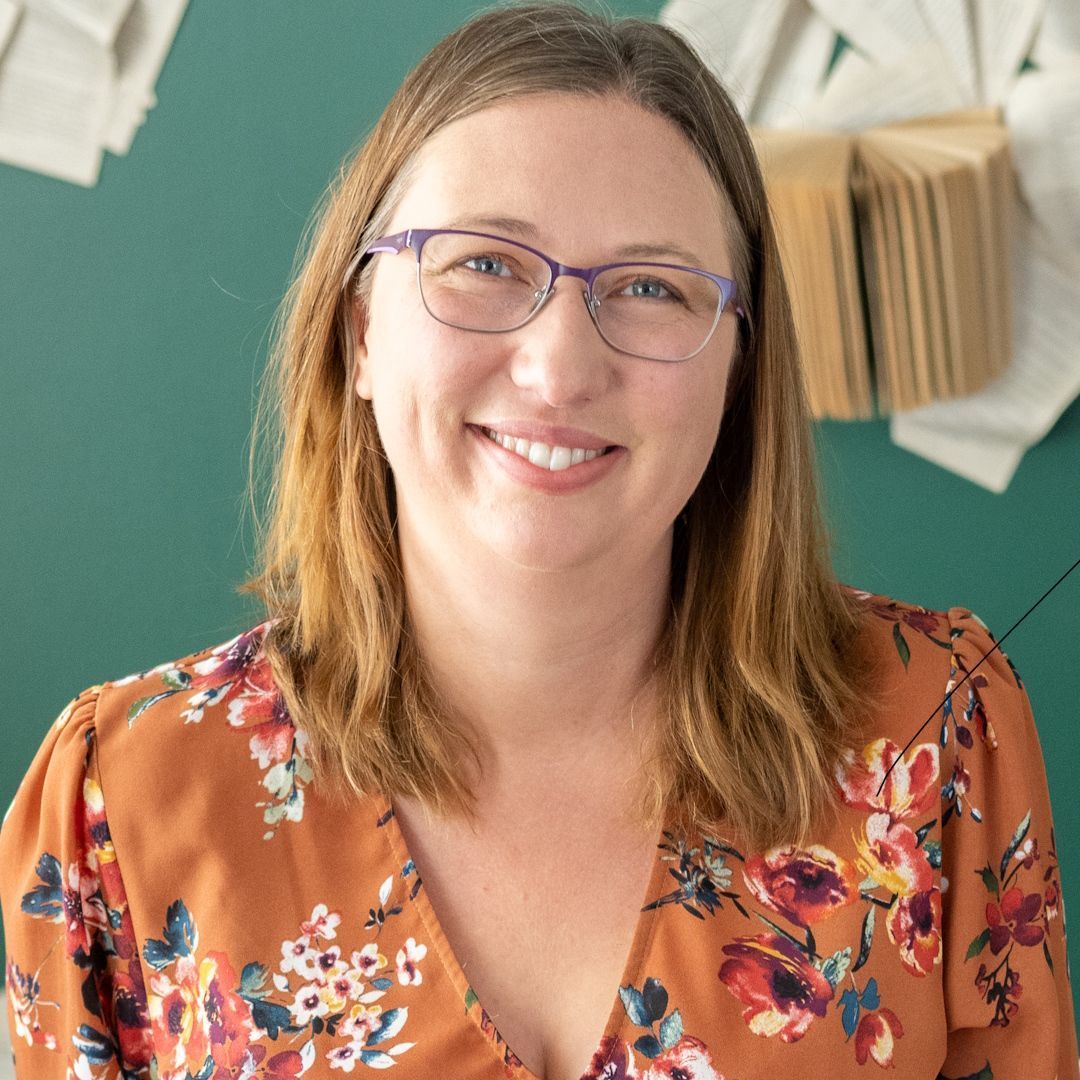 A man wearing a black shirt that says `` be great '' is giving a thumbs up.