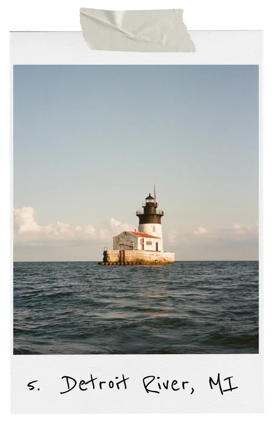 A Polaroid-style photo of the Detroit River Lighthouse, a white tower on a concrete pier surrounded by open water.