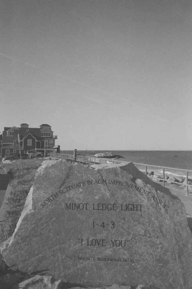 A black and white film photograph of the Minot Ledge lighthouse in Massachusetts