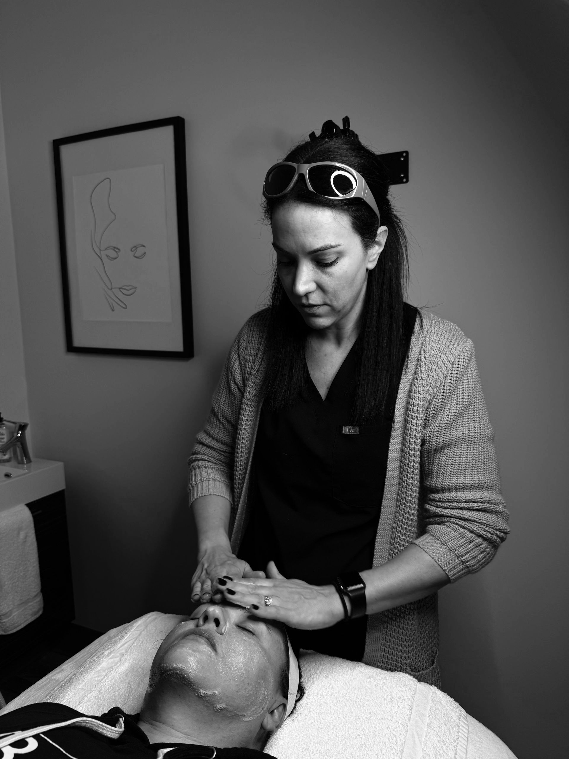 A woman is giving a man a facial in a black and white photo.