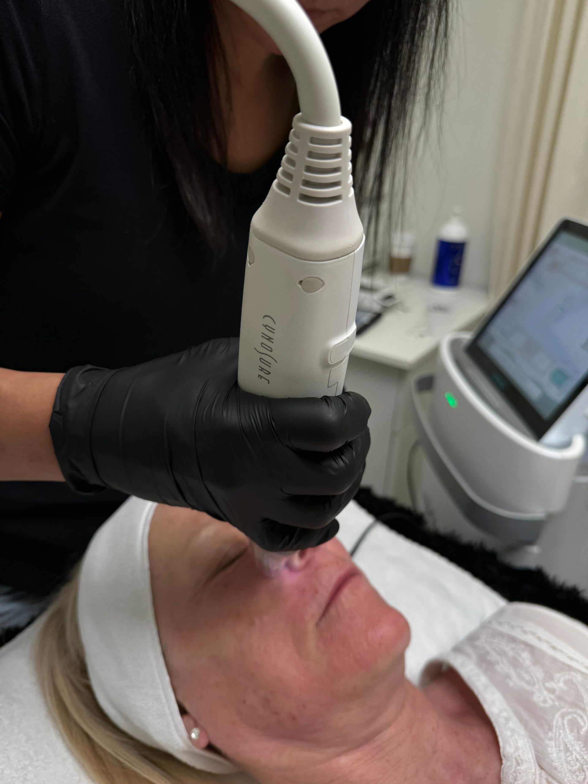A woman is getting a facial treatment with a machine.