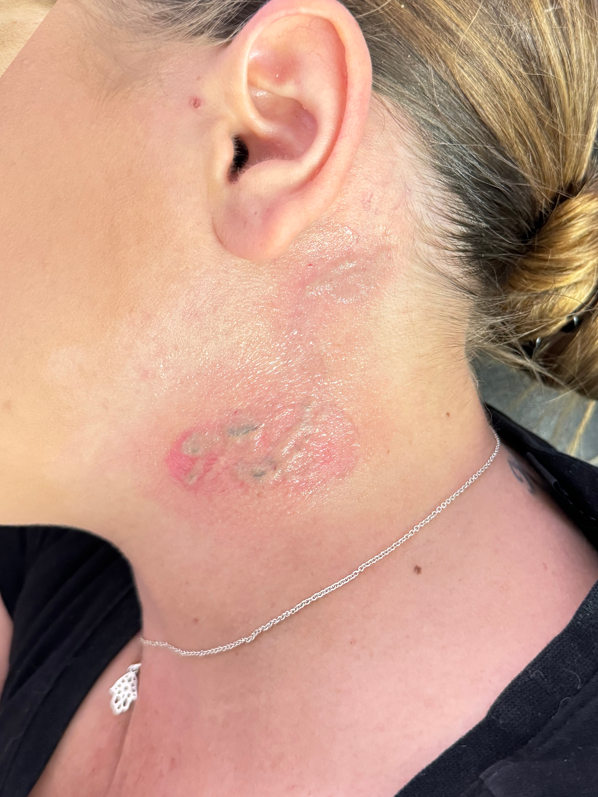 A close up of a woman 's neck with a tattoo on it.