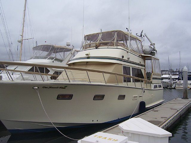 Cream-colored boat docked at a pier on a cloudy day. 