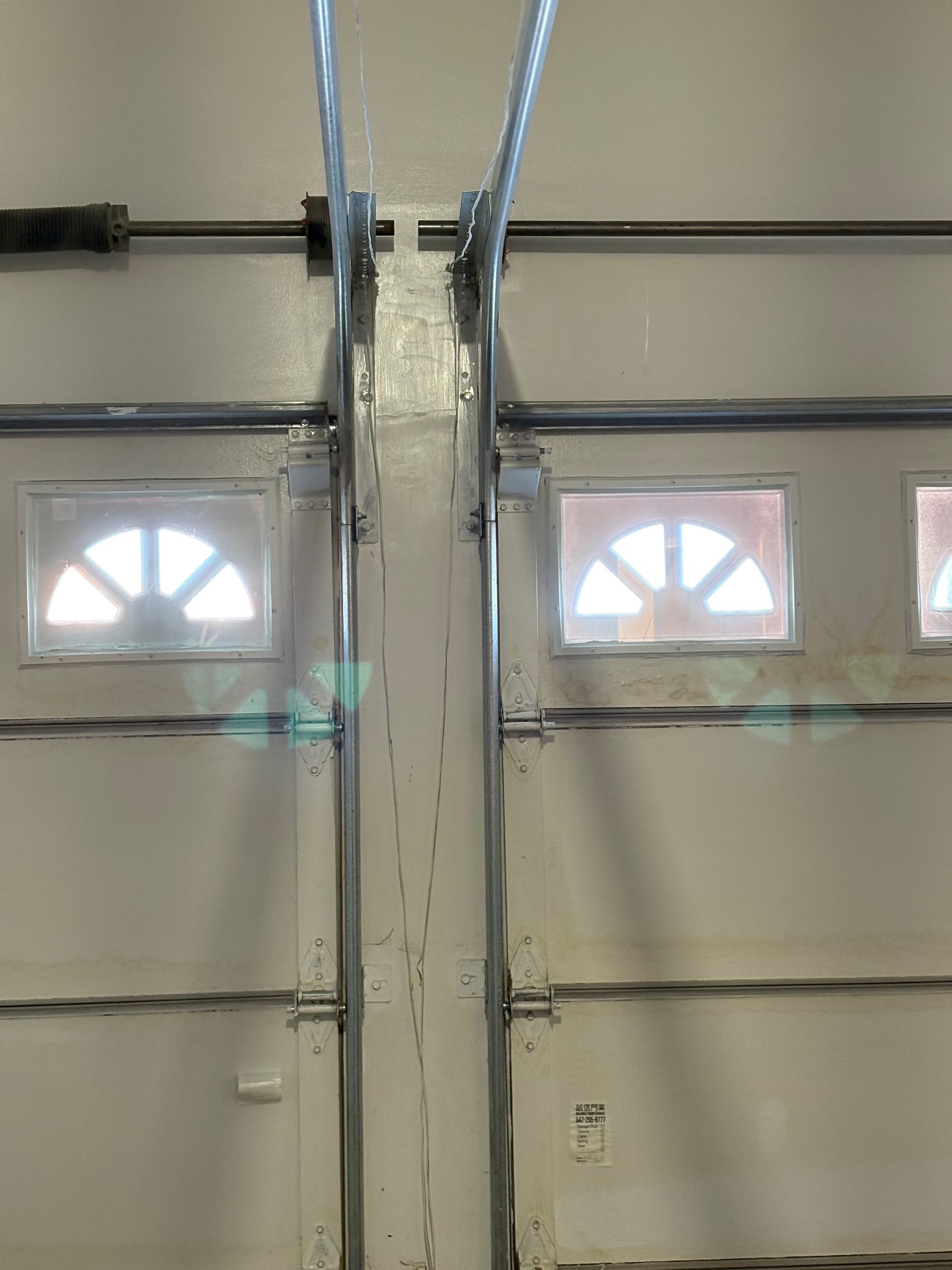 A close up of a garage door with two windows.