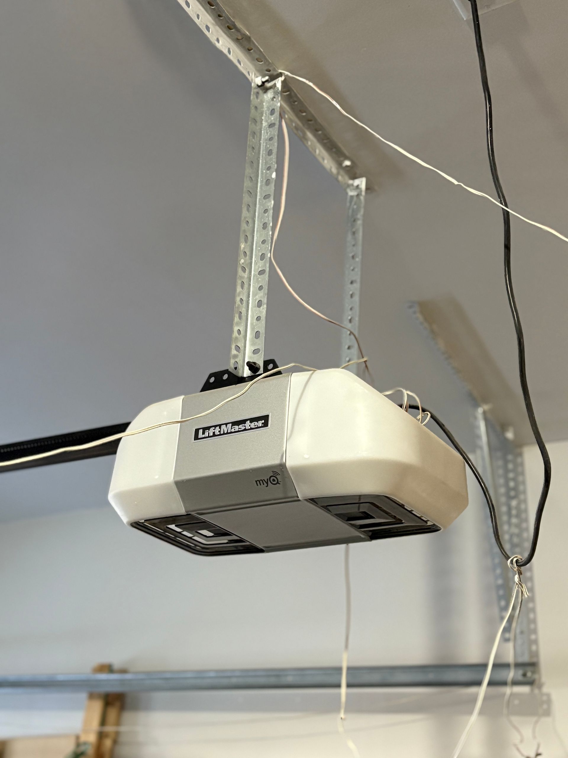 A white garage door opener is hanging from the ceiling