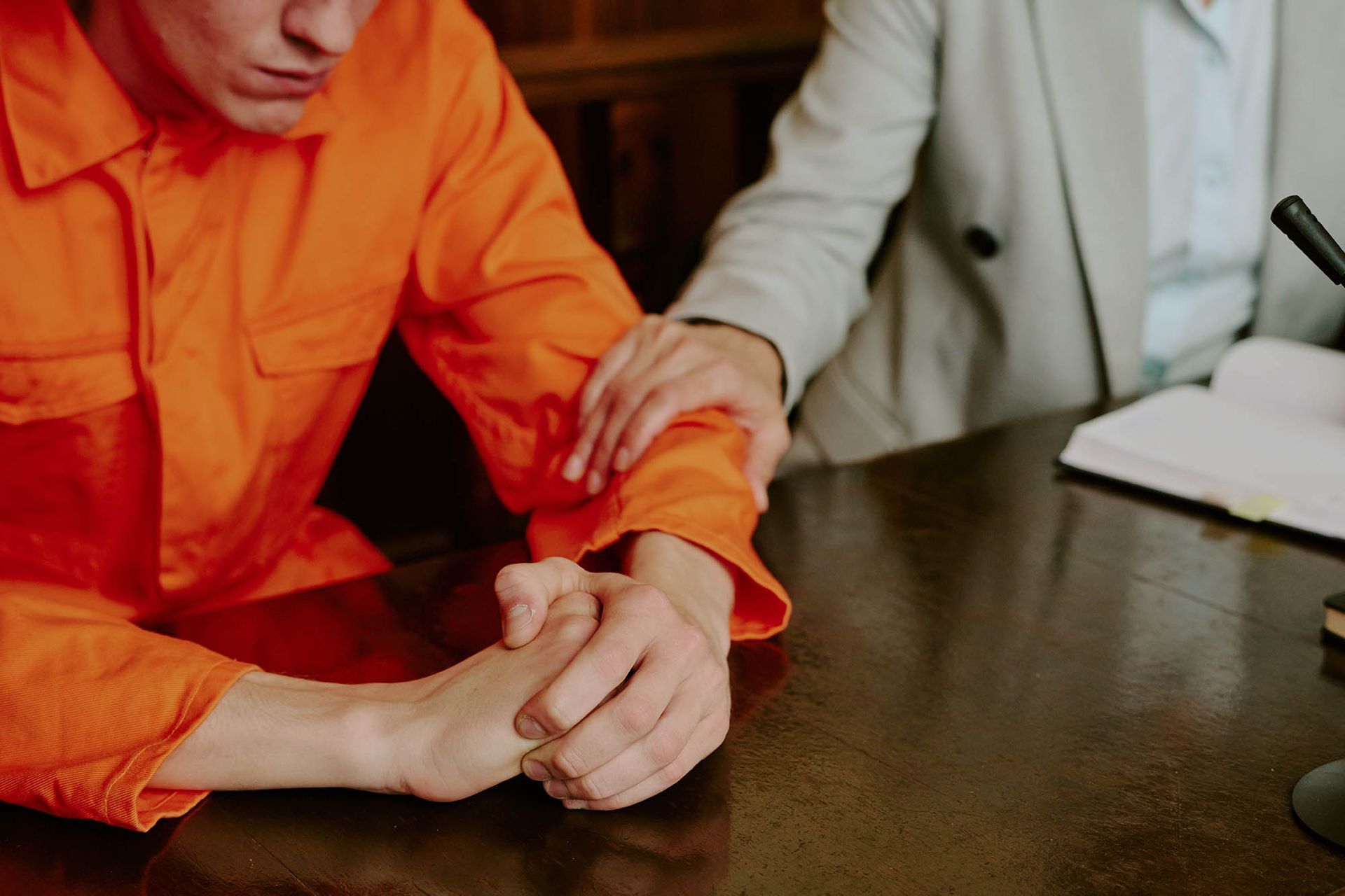 Attorney supporting detained client during criminal defense meeting. Attorney supporting detained client during criminal defense meeting.
