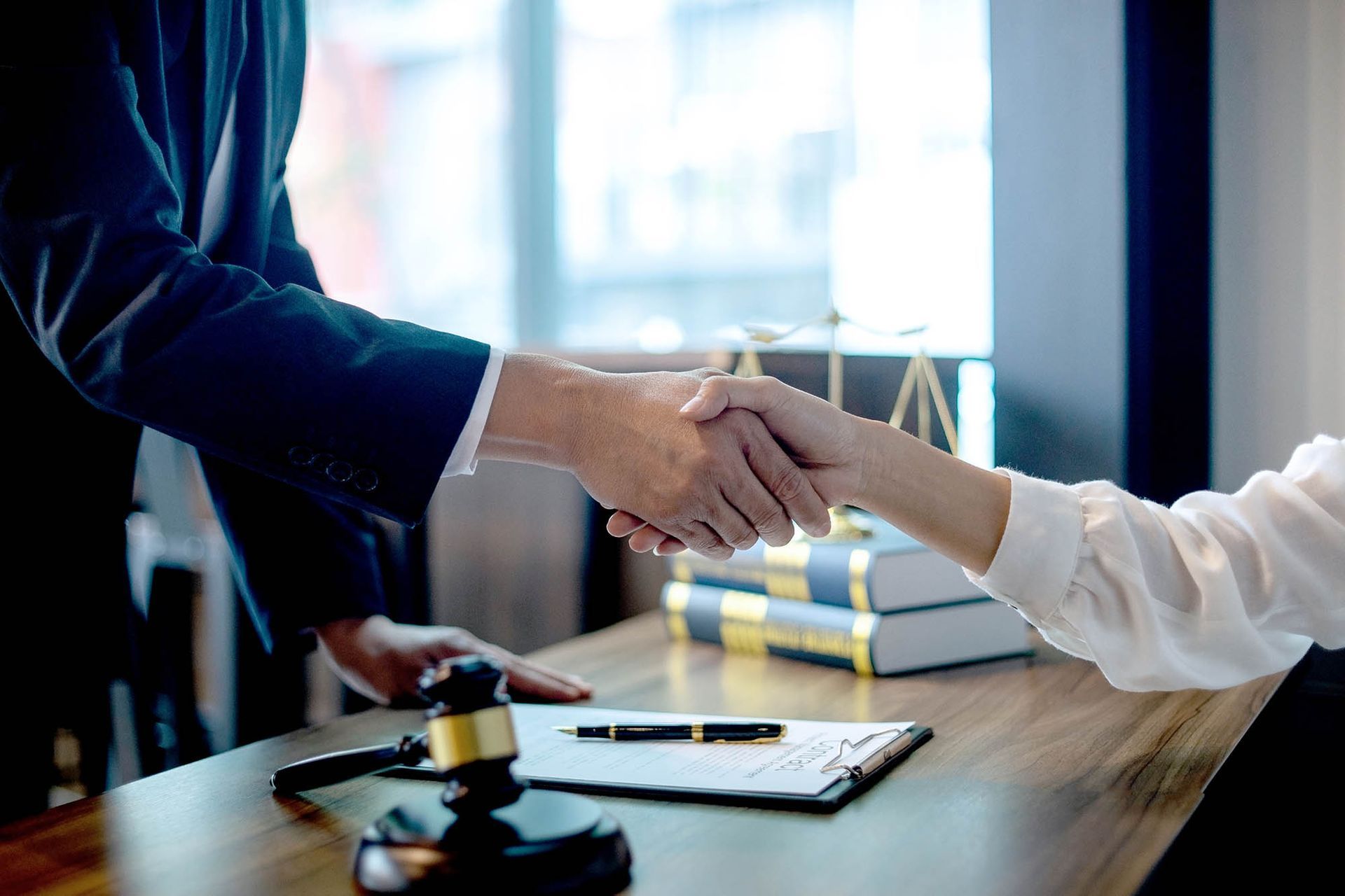 Lawyer and client shaking hands during a criminal defense meeting Lawyer and client shaking hands during a criminal defense meeting