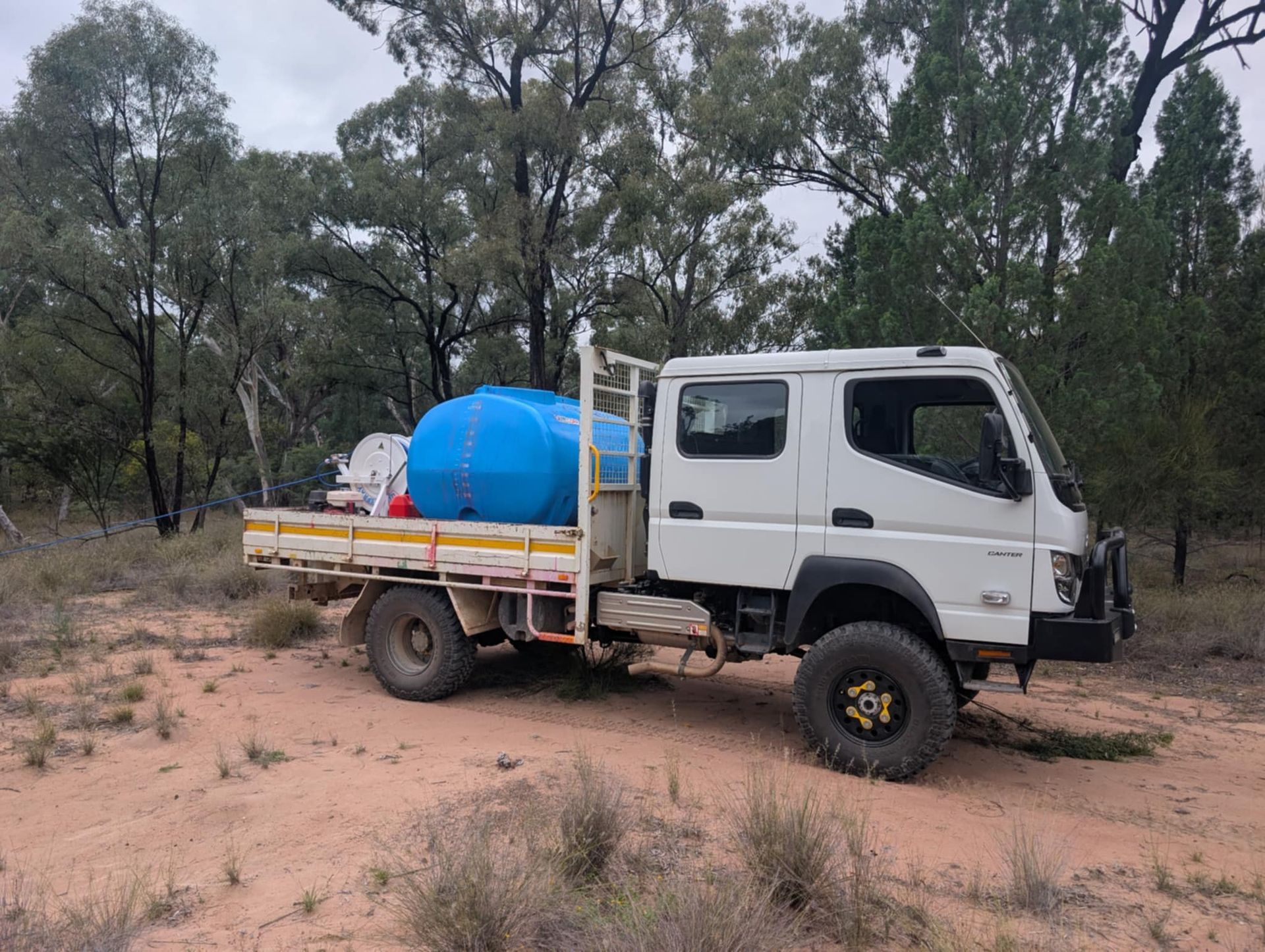 A Yellow Excavator is Cutting Grass in a Field — 2K Pasture Management and Consulting In Junction View, QLD