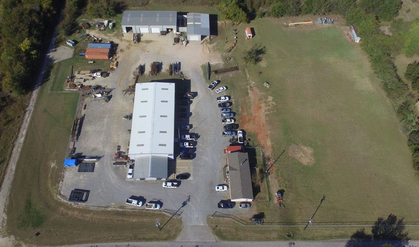 An aerial view of a building with a lot of cars parked in front of it