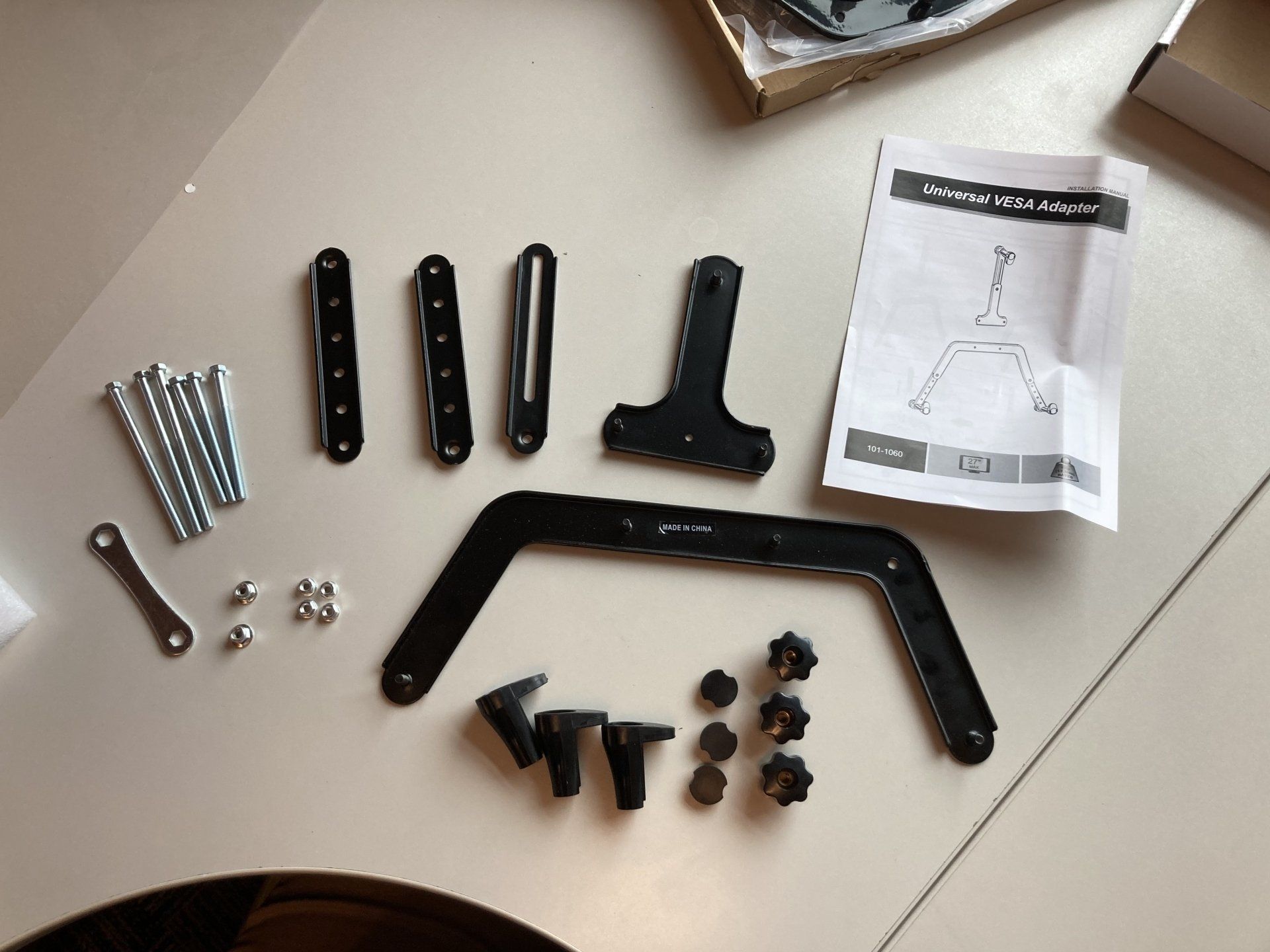 A bunch of screws and a piece of paper with the letter t on it