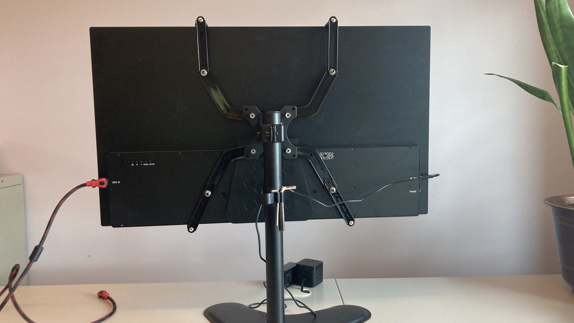 A computer monitor is sitting on a stand on a desk.
