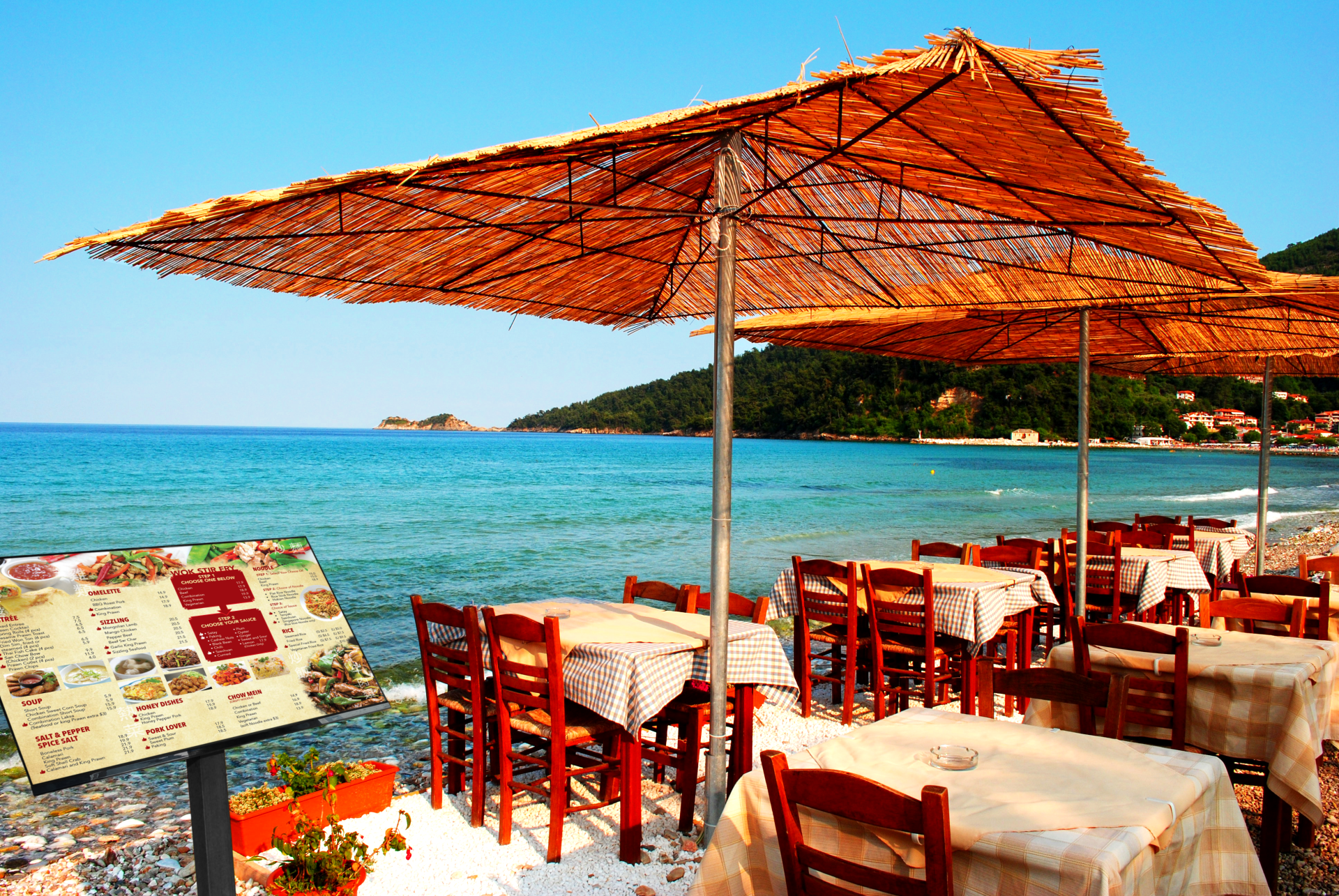 Tables and chairs under umbrellas on a beach near the ocean