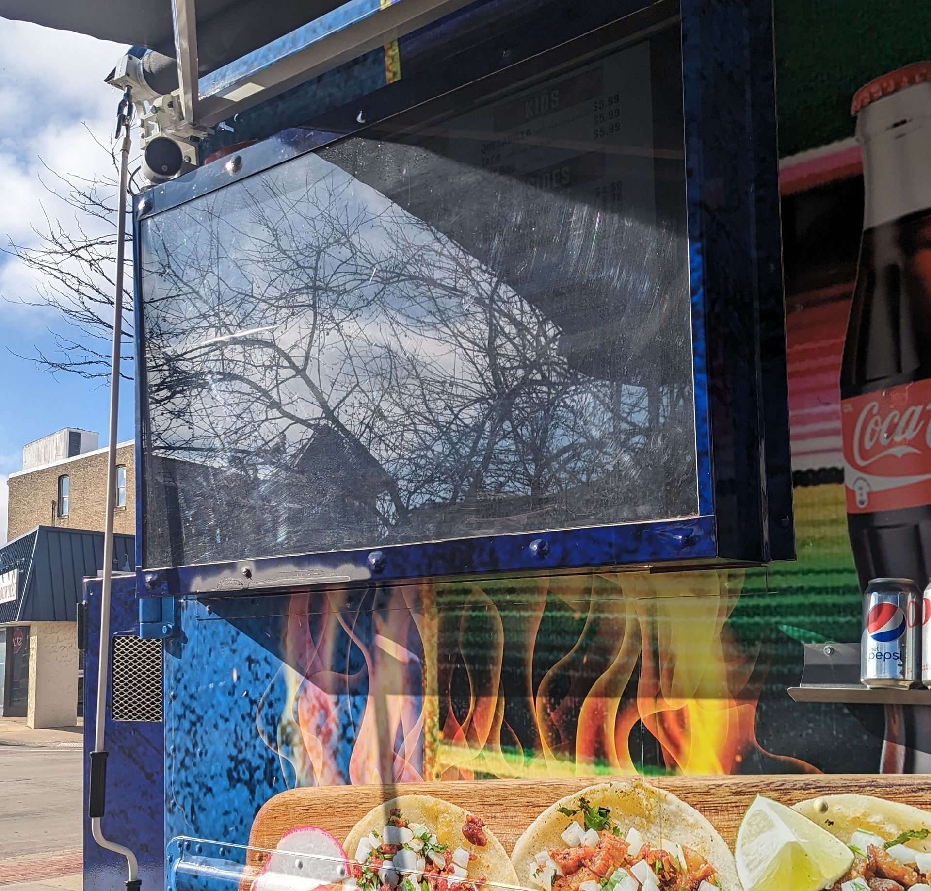 A coca cola bottle sits next to a food truck