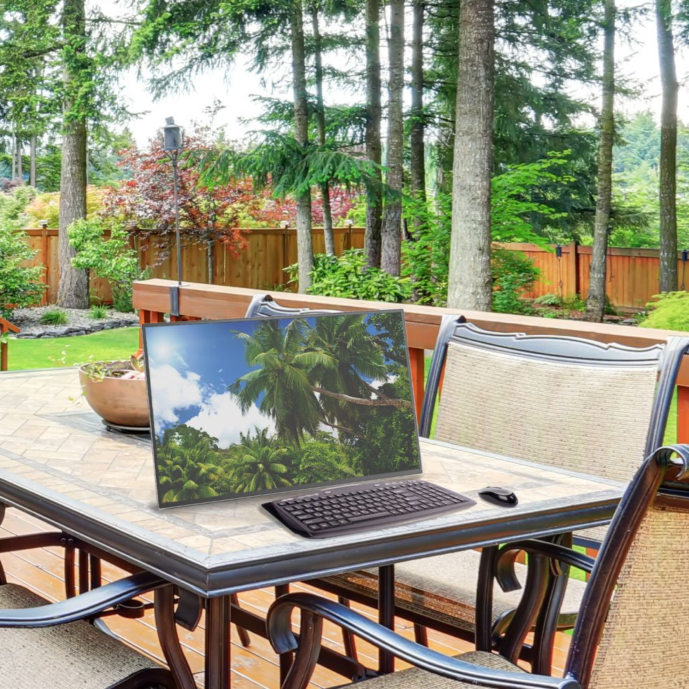 A laptop is sitting on a patio table with a picture of palm trees on it.