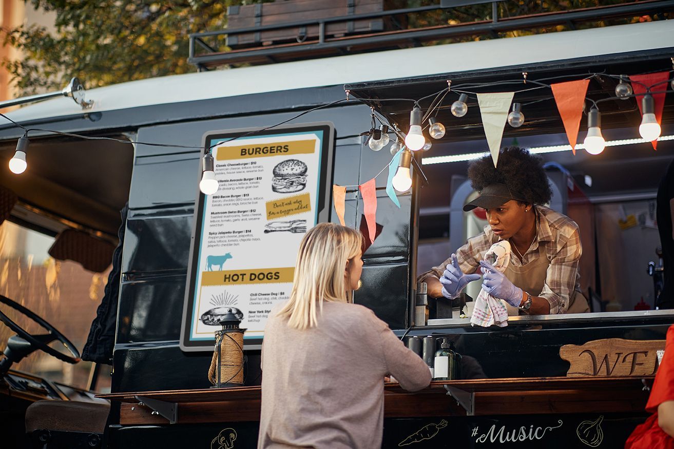 A woman is ordering food from a food truck.