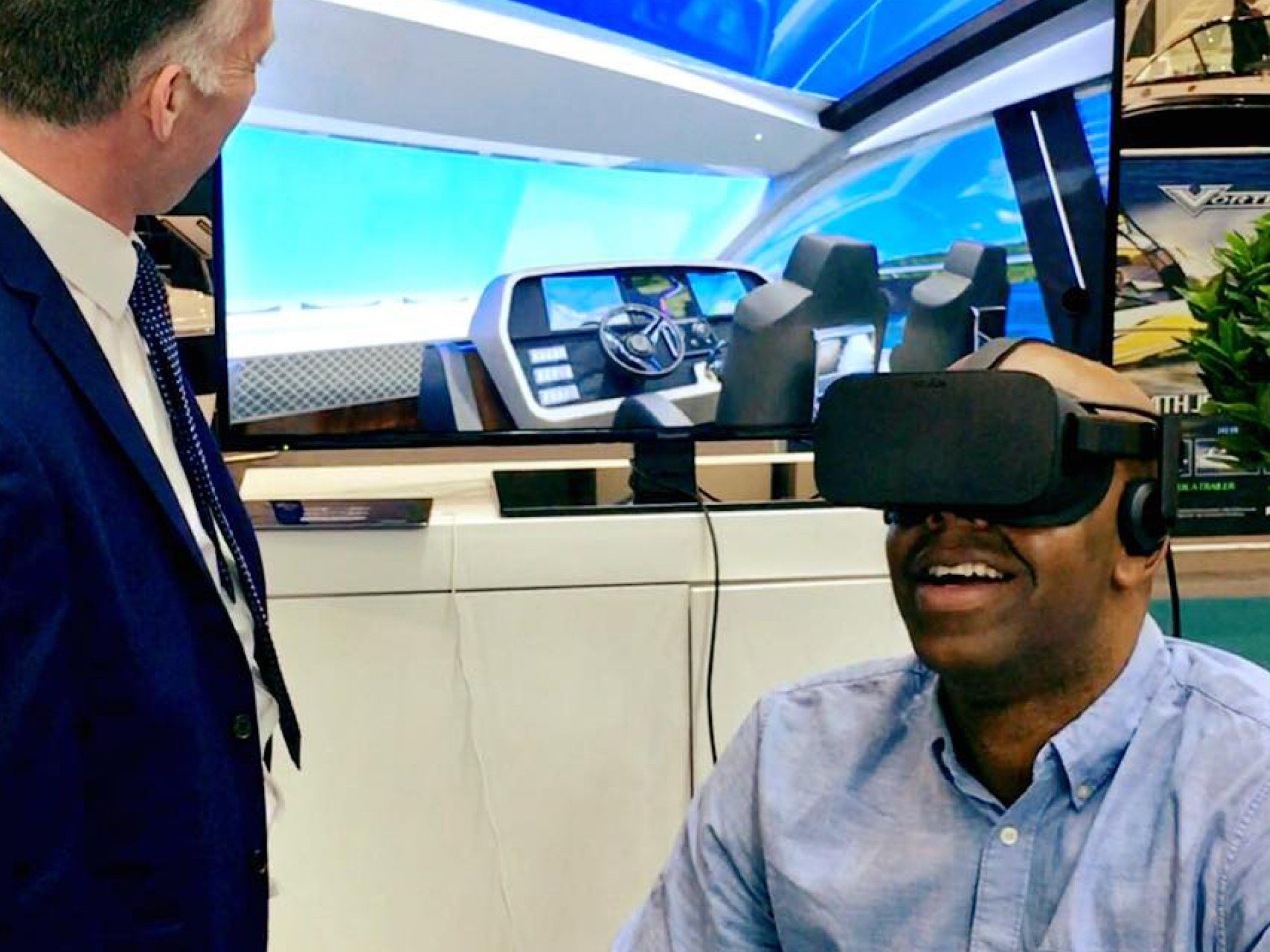 A man wearing a virtual reality headset talks to another man