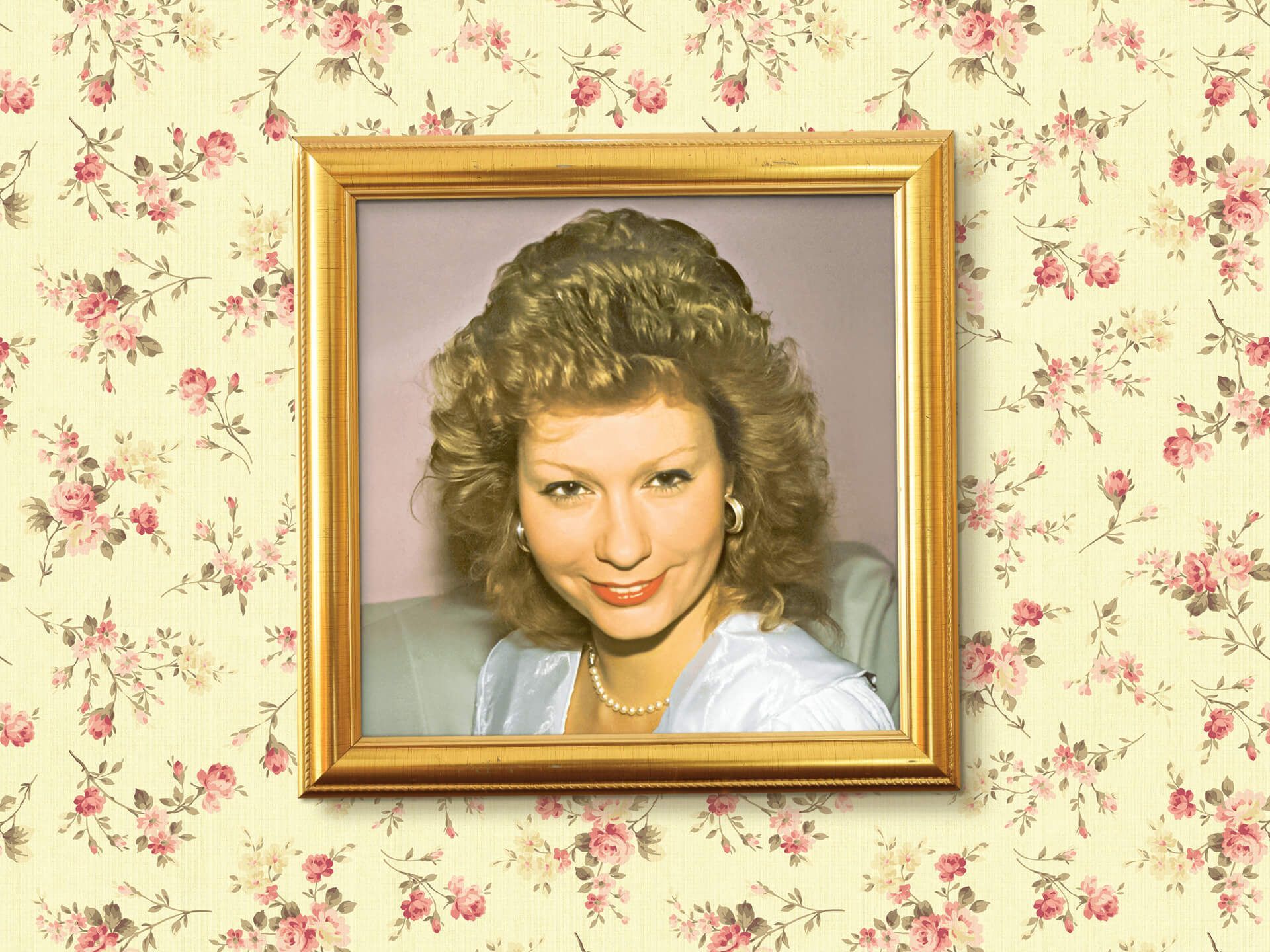 A picture of a woman in a gold frame on a floral wallpaper