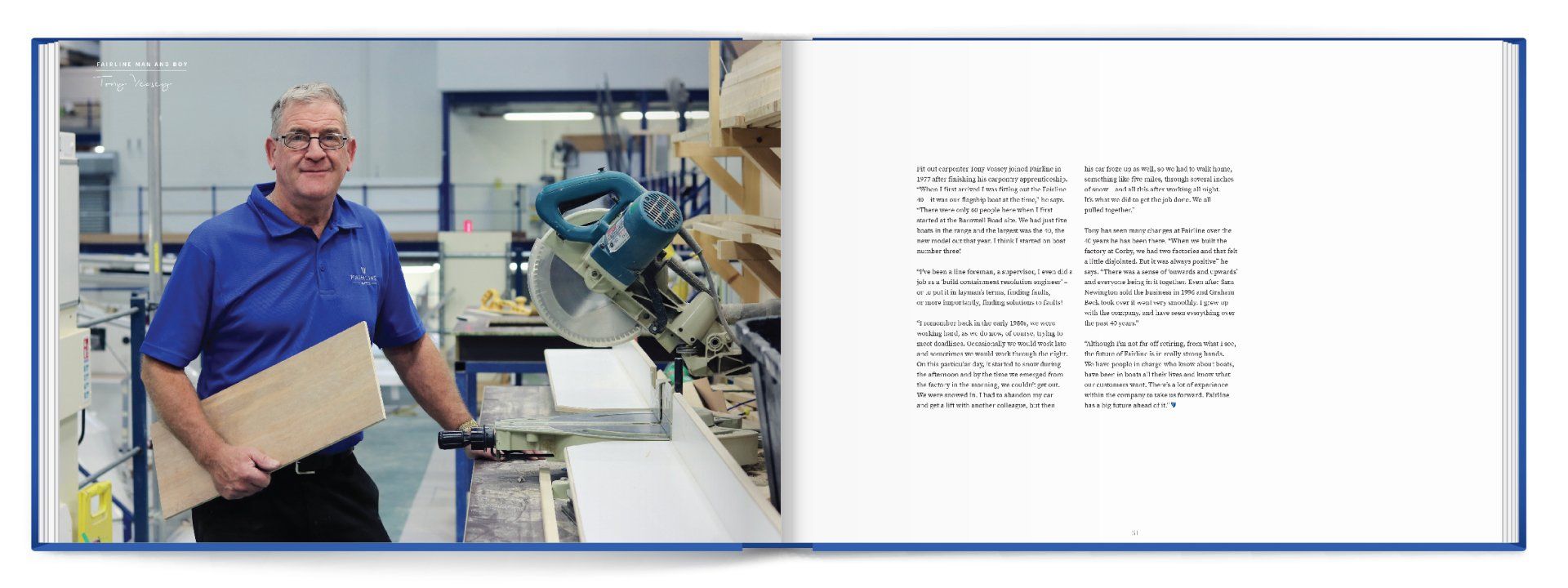 A man in a blue shirt is holding a piece of wood in a factory.
