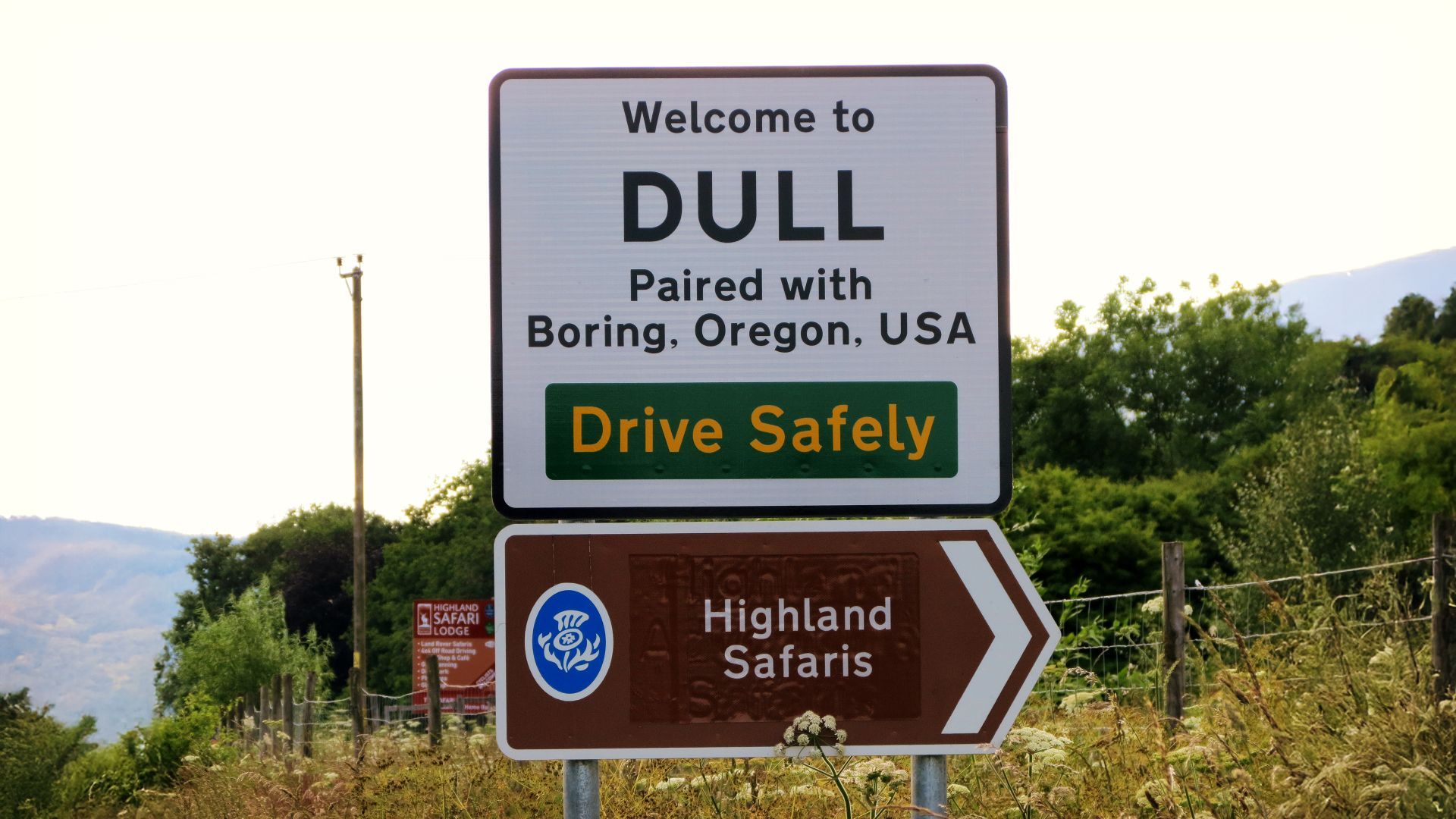 A sign that says welcome to dull paired with boring oregon usa