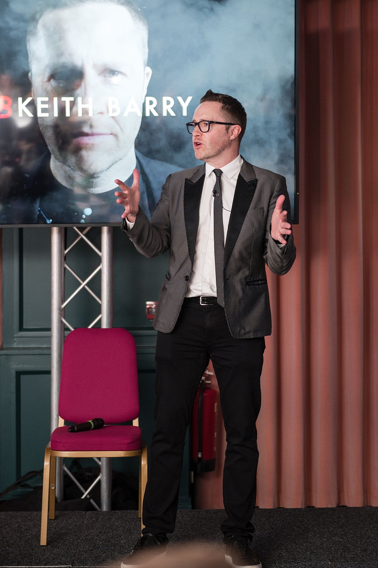 A man doing a talk on stage