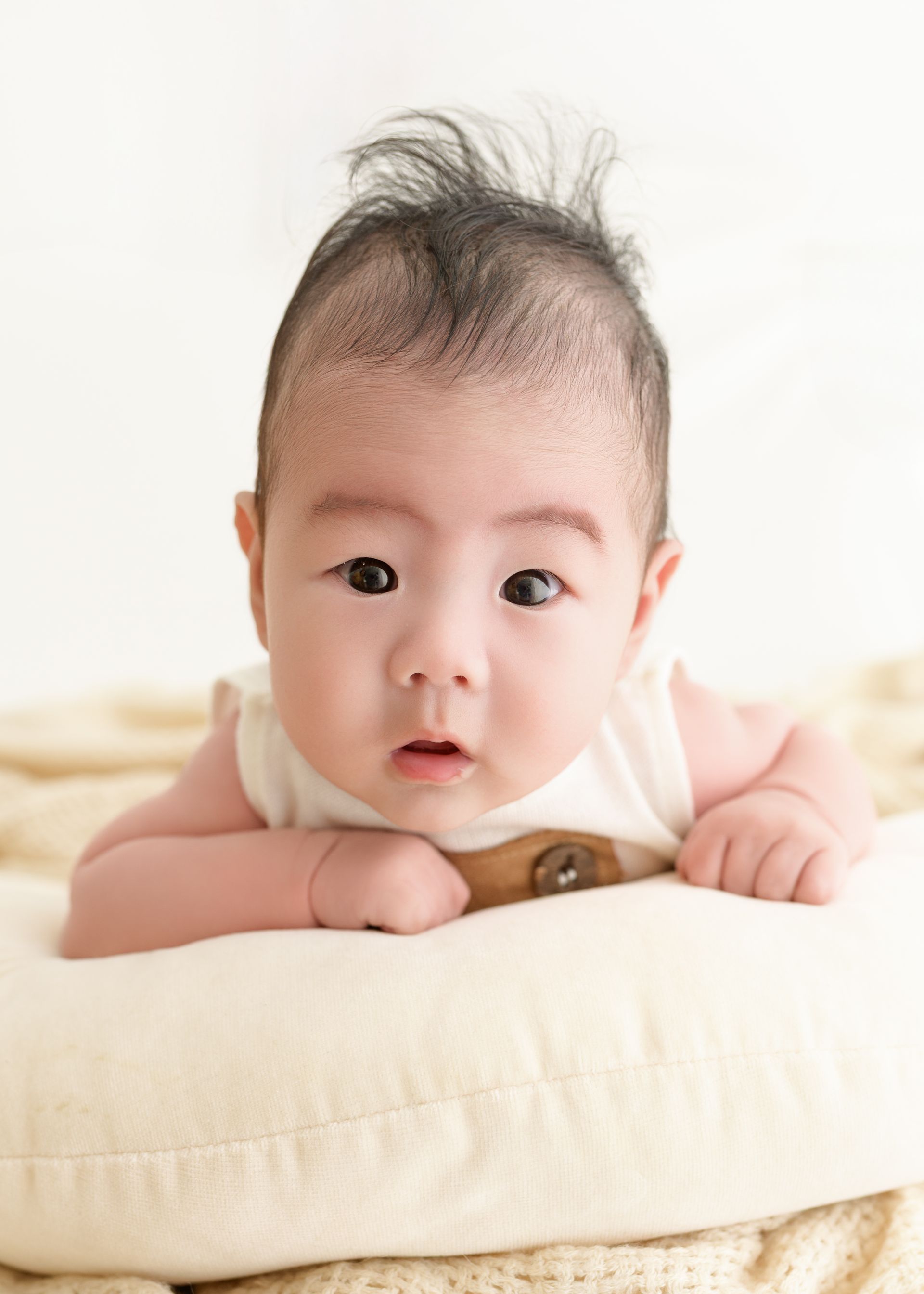 Wide-eyed baby enjoying a relaxed studio baby photography session in Dublin.