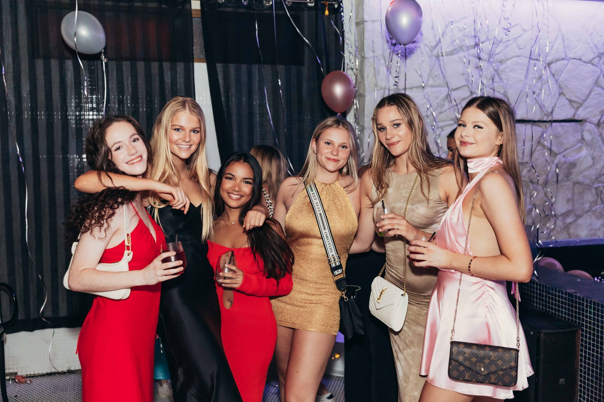 a group of women are posing for a picture at a party .