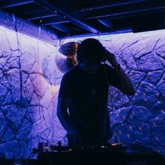 a man wearing headphones stands in front of a magma turntable